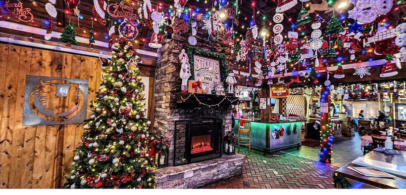 A festive Christmas tree and fireplace glowing inside a transformed restaurant