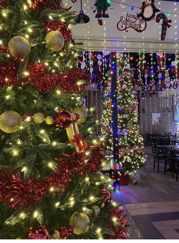 A lushly decorated Christmas tree surrounded by lights and garland