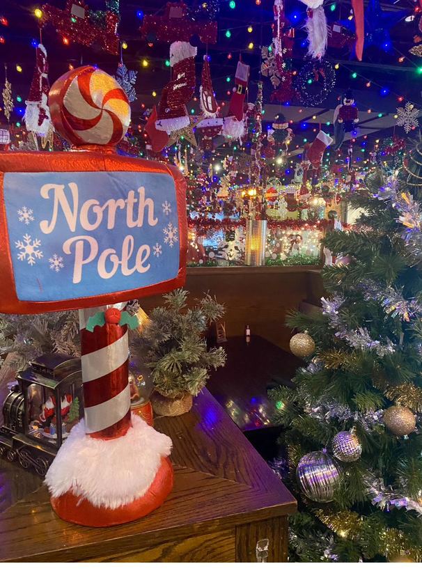 A whimsical North Pole signpost tucked into the decorations