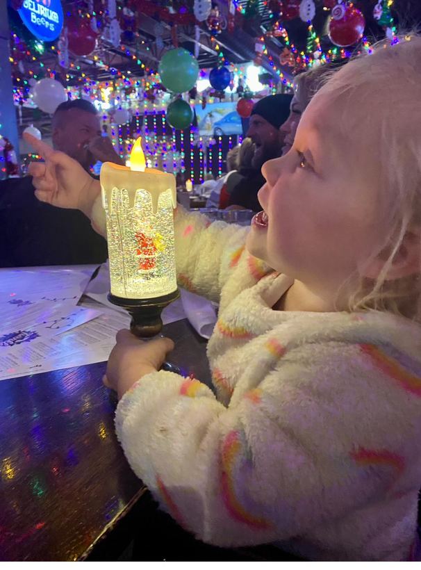 A delighted child holding a glowing snow globe