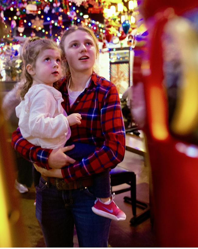 A parent and child taking in all the twinkling lights