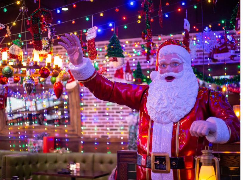 Santa greeting guests among the glowing lights